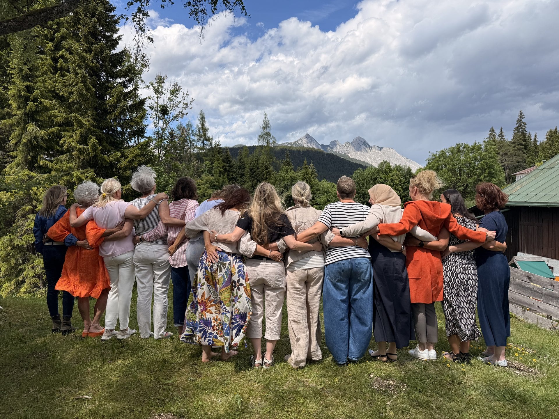 Teilnehmerinnen einer FreyMuT-Fortbildung Arm in Arm vor Bergpanorama