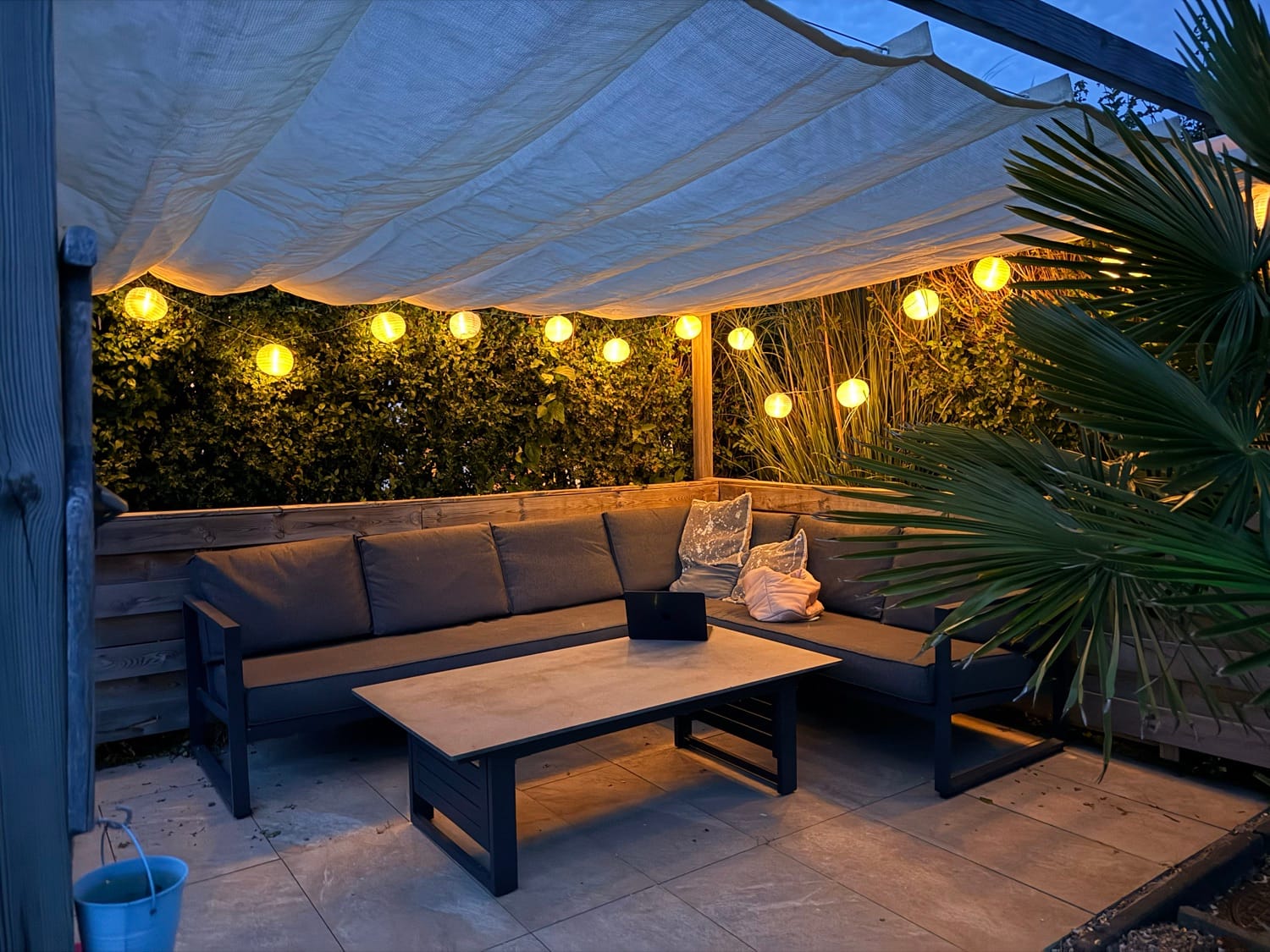 Terrasse am Abend mit Lichterkette und Sitzecke