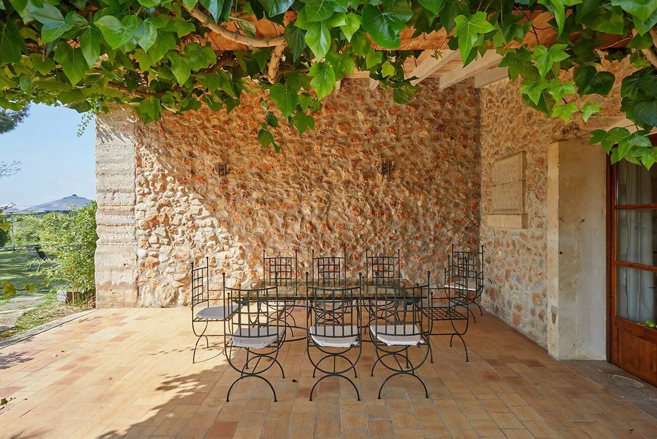 Ein schattiger Platz unter Weinlaub an einer alten Steinmauer