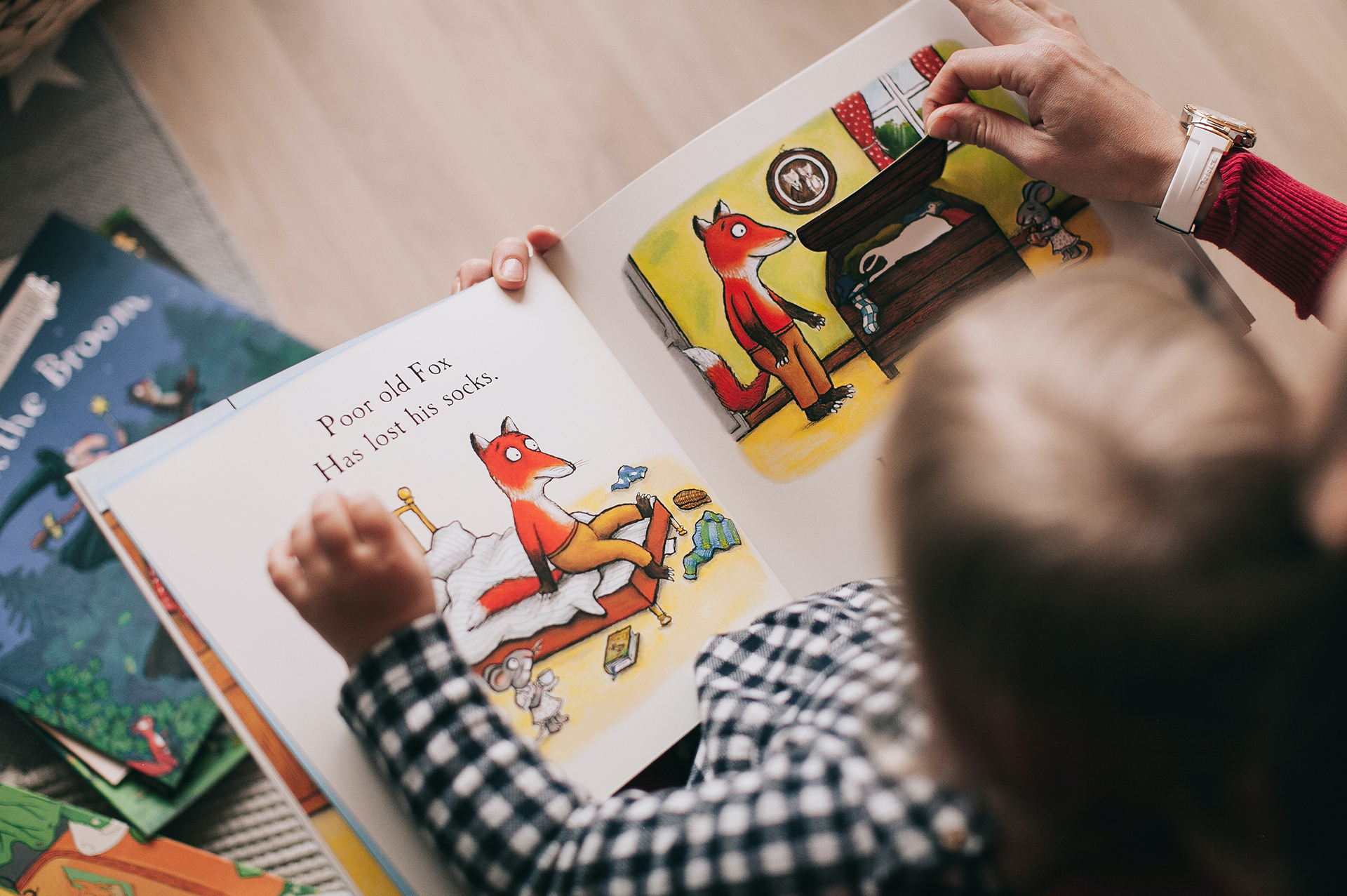 Kind liest mit einem Erwachsenen ein Buch