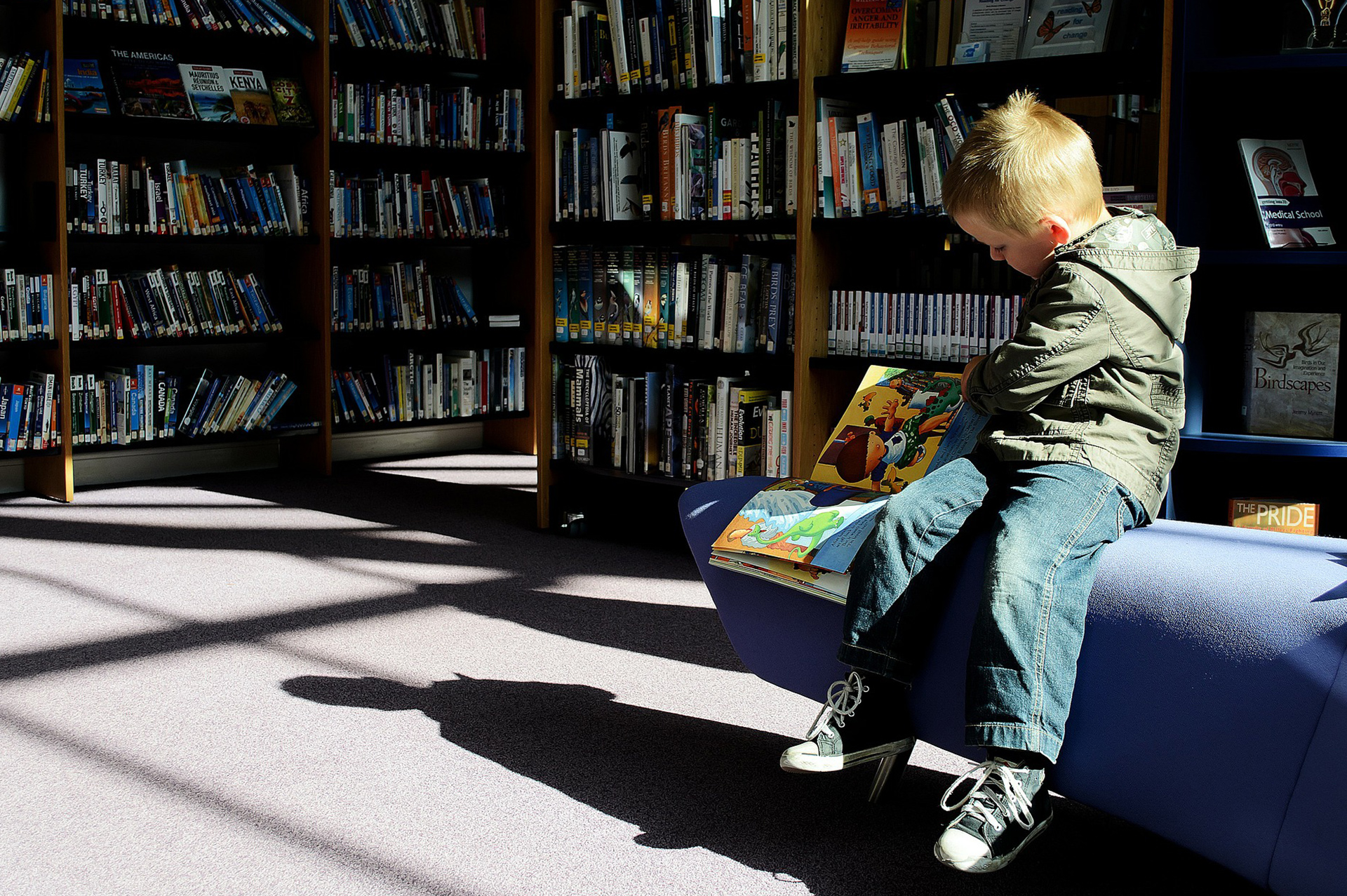 Junge schaut sich ein Buch in der Bibliotek an